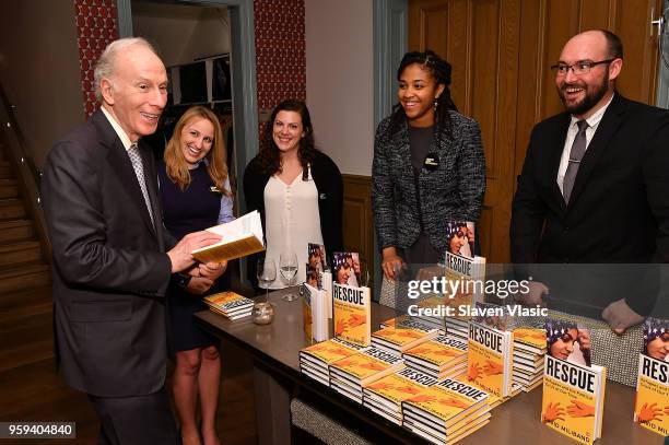 Staff giving away copies of "Rescue, Refugees and the Political Crisis of Our Time" books at "This is Home: A Refugee Story" - New York Premier...