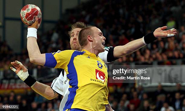 Oliver Roggisch of Germany battles for the ball with Lukas Karlsson of Sweden during the Men's Handball European Championship Group C match between...