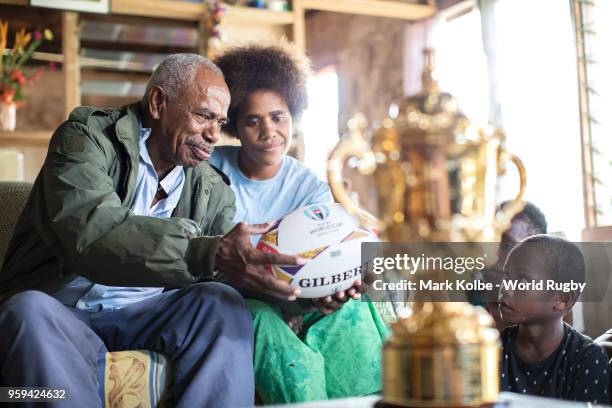 Apakuki Saisai and his family and friends sit with the Webb Ellis Cup in his house during Rugby World Cup 2019 Trophy Tour on May 17, 2018 in Galoa...