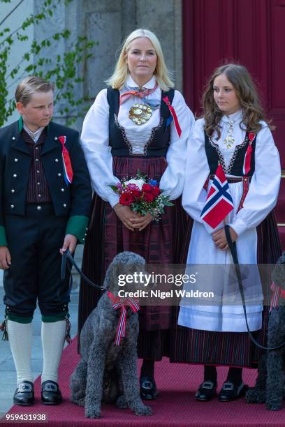 Prince Sverre Magnus of Norway, Princess Mette Marit of Norway and Princess Ingrid Alexandra of Norway wearing their national costumes and standing...