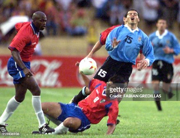 Carlos Morales of Uruguay collides with Mauricio Solis of Costa Rica as Jervis Drummond looks on, 22 July 2001, at the Centenario stadium in Armenia,...