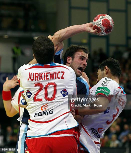 Mariusz Jurkiewicz and Krysztof Lijewski of Poland challenge Uros Zorman of Slovenia during the Men's Handball European Championship Group C match...