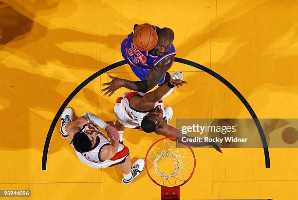 Shaquille O'Neal of the Cleveland Cavaliers shoots over Chris Hunter and Vladimir Radmanovic of the Golden State Warriors during the game at Oracle...