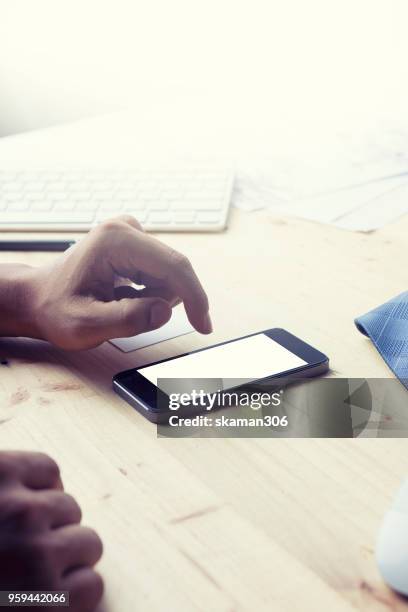 man's hands holding a blank card and using smart phone for business - data entry keyboard stock pictures, royalty-free photos & images