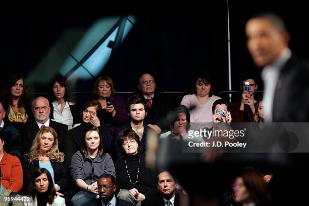 People listen as U.S. President Barack Obama speaks during a town hall meeting with Ohio students, workers, local leaders and small business owners...