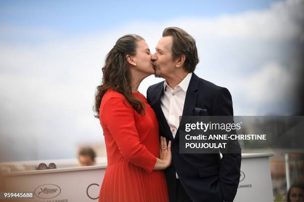 British actor Gary Oldman kisses his wife Gisele Schmidt on May 17, 2018 during a "Rendez-Vous with Gary Oldman" at the 71st edition of the Cannes...