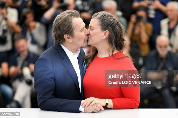 British actor Gary Oldman kisses his wife Gisele Schmidt on May 17, 2018 during a "Rendez-Vous with Gary Oldman" at the 71st edition of the Cannes...