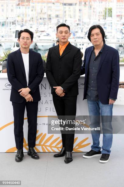 Actors Steven Yeun, Ah-in Yoo and director Lee Chang-dong attend the photocall for the "Burning" during the 71st annual Cannes Film Festival at...