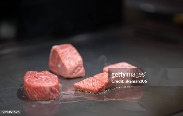 japanese chef cooking beef for client teppanyaki style - teppanyaki stock-fotos und bilder