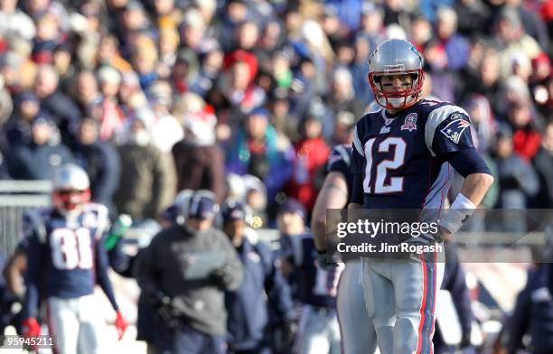 Tom Brady of the New England Patriots looks on as Randy Moss watches from the sideline against the Baltimore Ravens during the 2010 AFC wild-card...