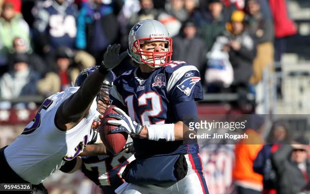 Tom Brady of the New England Patriots looks to pass against pressure from Terrell Suggs of the Baltimore Ravens during the 2010 AFC wild-card playoff...