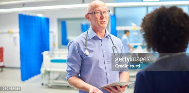 senior doctor with nurse - sturti stock pictures, royalty-free photos & images