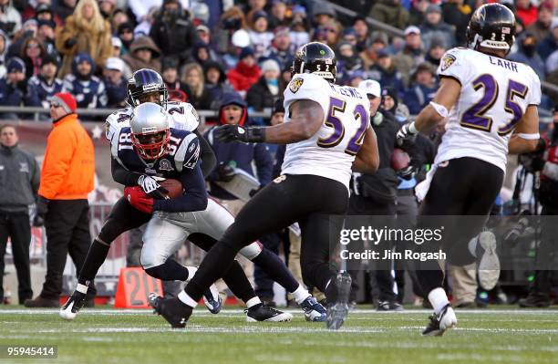 Randy Moss of the New England Patriots attempts to run for yards after the catch against Chris Carr, Dominique Foxworthy and Ray Lewis of the...