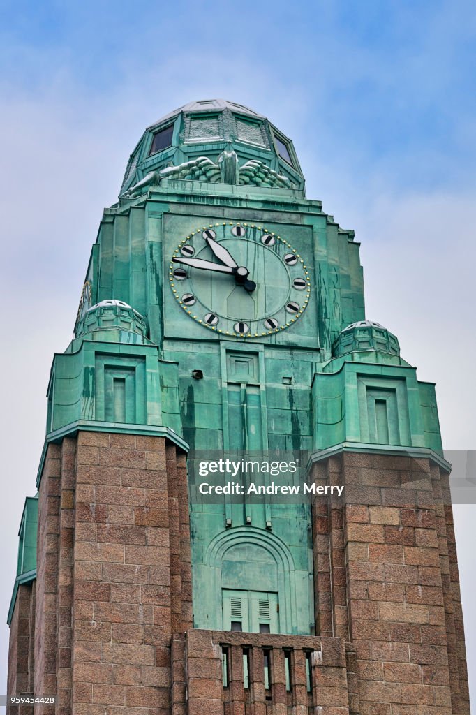 Helsinki Central Station, closeup of clock tower with snow and blue sky, Finland