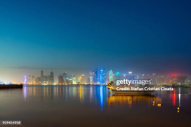 doha skyline at dusk in qatar - dhow qatar stock pictures, royalty-free photos & images