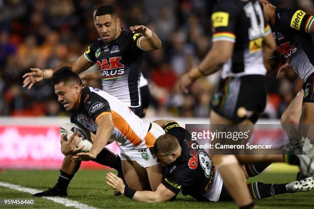 Sauaso Sue of the Tigers is tackled during the round 11 NRL match between the Penrith Panthers and the Wests Tigers at Panthers Stadium on May 17,...