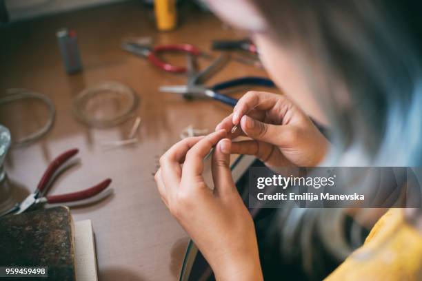 woman designer makes and design jewelry in workshop - tiny hands stock-fotos und bilder