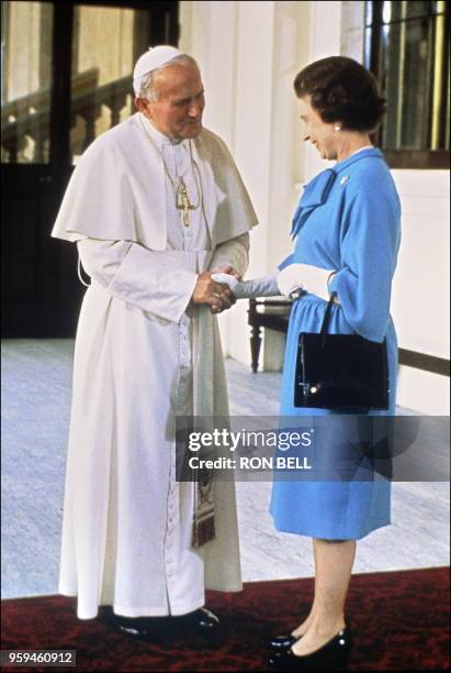The Queen Elizabeth II and Pope John Paul II shake hand as the Pontiff leaves Buckingham Palace 28 May in London, after their historic meeting. John...