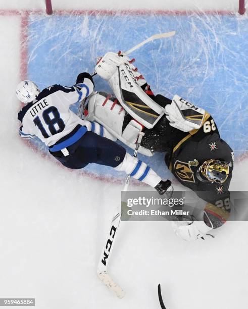 Bryan Little of the Winnipeg Jets slides into Marc-Andre Fleury of the Vegas Golden Knights after taking a shot in the second period of Game Three of...