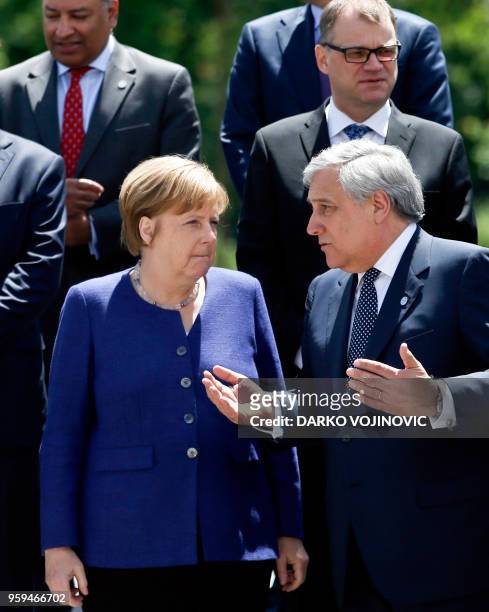 German Chancellor Angela Merkel speaks with European Parliament President Antonio Tajani as they pose for a family photo during an EU-Western Balkans...
