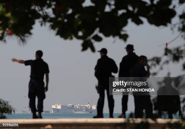 Members of the US Coast Guard stand by the port as the USNS Comfort hospital ship lies anchored in the background on 22 January, 2010 in...