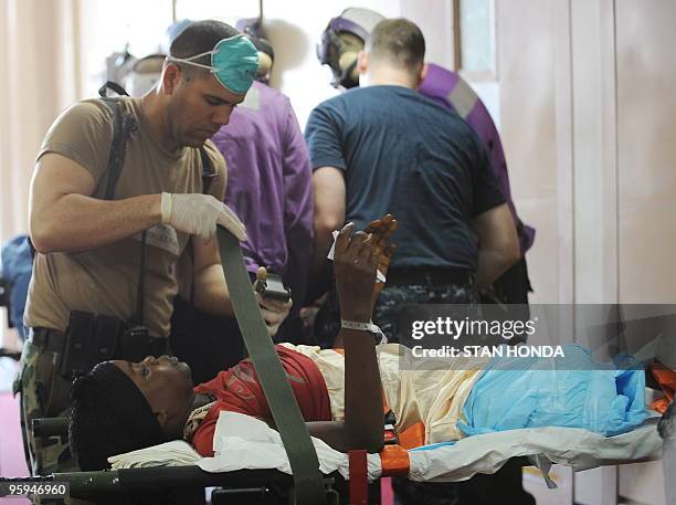 Medical personel assist Hatian earthquake victims who arrived by medical helicopter aboard the USNS Comfort hospital ship on 22 January, 2010 in the...
