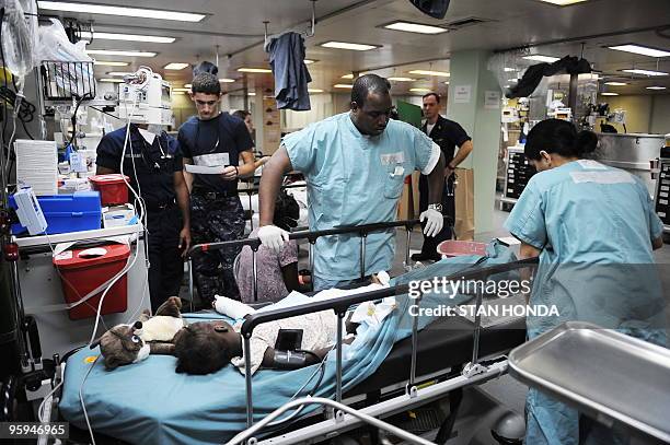Doctors treat a young Hatian earthquake victim aboard the USNS Comfort hospital ship on 22 January, 2010 in the harbor off Port-au-Prince, Haiti. AFP...