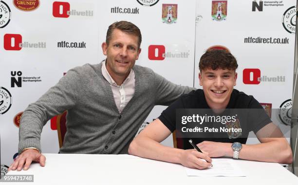 Northampton Town manager Dean Austin looks on as Sean Whaler of Northampton Town sign their first Pro contract watched by Manager Dean Austin at...