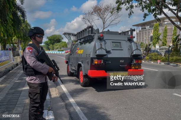 Policeman stands guard outside the police headquarters, a day after an attack at the venue, in Pekanbaru on May 17, 2018. - Four men who attacked an...