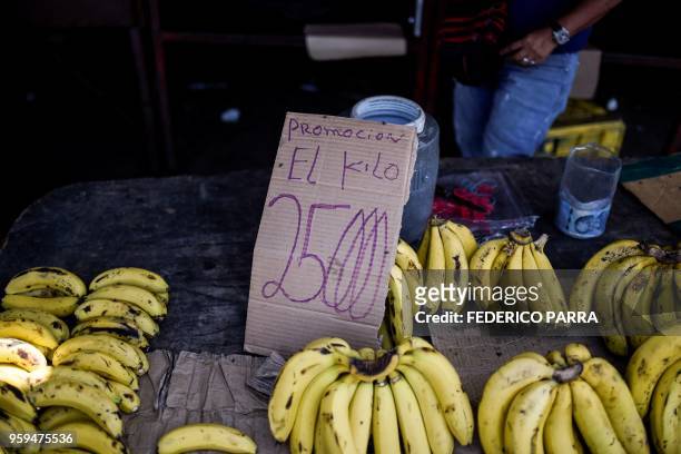 Man sells bananas in a street in Maracaibo, Venezuela on May 3, 2018. - Amid blackouts, skyrocketing prices, shortage of food, medicine and...