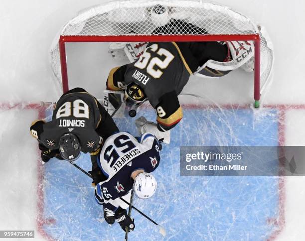 Marc-Andre Fleury of the Vegas Golden Knights gets pushed into his net after blocking a shot by Mark Scheifele of the Winnipeg Jets as Nate Schmidt...