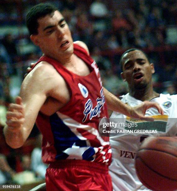 Daneil Santiago of Puerto Rico dribbles past Oscar Torres of Venezuela during the second round of the Pre-World Basketball Tournament in the Ruca-Che...