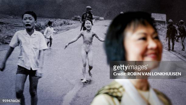 Vietnam war survivor Kim Phuc Phan Thi, also known as "Napalm Girl", stands in front of her iconic 1972 Vietnam War photograph showing her running on...