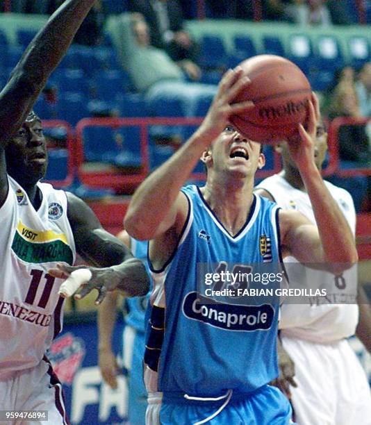 Juan Moltedo of Uruguay shoots the ball while being guarded by Carl Herrrera of Venezuela during a game in the Ruca-Che Stadium in Neuquen, Argentina...