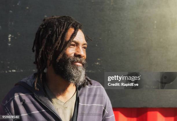 dakloze man met dreadlocks en glimlacht wistfully baard - homeless person stockfoto's en -beelden