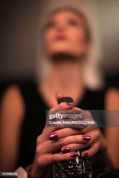 Model holds a bottle of water as she gets her makeup done in the backstage of the Andre Lima fashion show, as part of the 2010-2011 Fall-Winter...