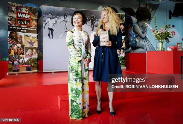 Vietnam war survivor Kim Phuc Phan Thi, also known as "Napalm Girl", stands in front of her iconic 1972 Vietnam War photograph showing her running on...