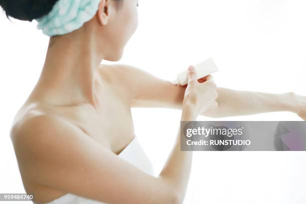 woman applying moisturizer on arm - face arms stock pictures, royalty-free photos & images