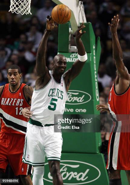 Kevin Garnett of the Boston Celtics passes the ball over Martell Webster and LaMarcus Aldridge of the Portland Trailblazers at the TD Garden on...