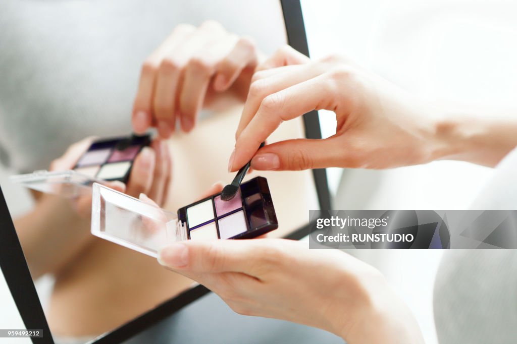 Close up of woman holding eye shadow pallet