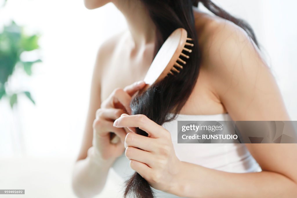 Close up of woman brushing hair