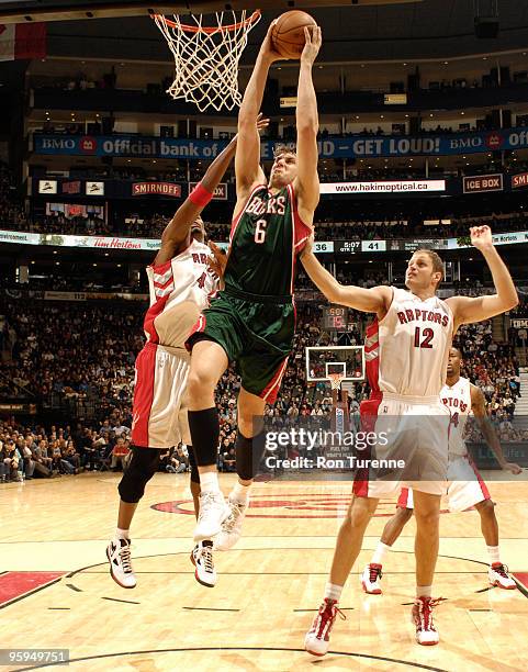 Andrew Bogut of the Milwaukee Bucks drives the lane and looks to finish with the two-handed monster jam in front of Chris Bosh and Rasho Nesterovic...