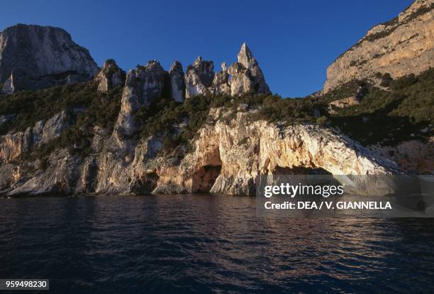 The natural stone arch and pinnacle of Cala Goloritze at sunrise, National Park of the Bay of Orosei and Gennargentu, Ogliastra, Sardinia, Italy.