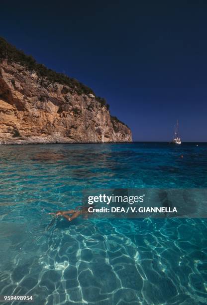 Bather swimming at Cala dei Gabbiani, National Park of the Bay of Orosei and Gennargentu, Ogliastra, Sardinia, Italy.