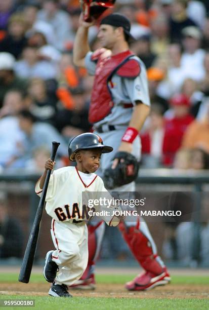 Bat boy Darren Baker , son of San Francisco Giants' manager Dusty Baker, collects a bat during game 4 of the National League Championship Series...