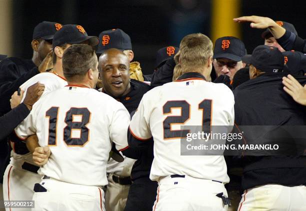 Barry Bonds of the San Francisco Giants is surrounded by teammates after clinching the National League Championship against the St. Louis Cardinals...