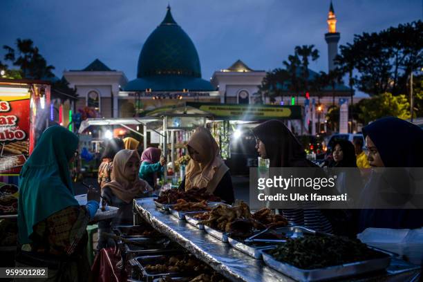 Muslim women looking for food as prepare for iftar on the first day of the holy month of Ramadan at the yard of Grand mosque on May 17, 2018 in...
