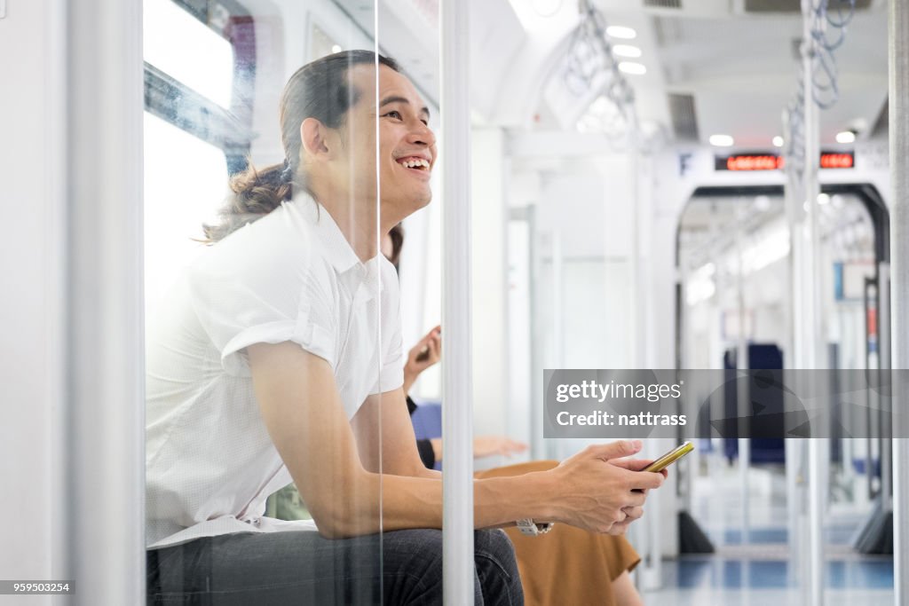 Man zit op de trein en werkt op zijn mobiele telefoon