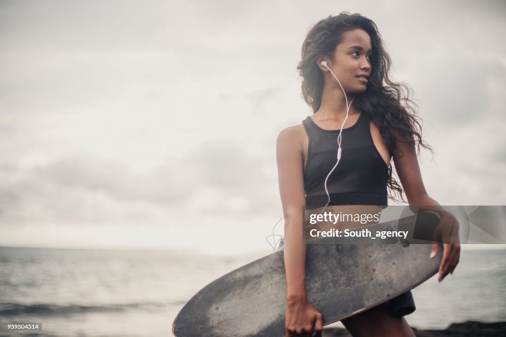 Beautiful skater woman at the beach