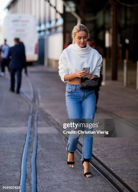 Guest wearing heels, ripped denim jeans during Mercedes-Benz Fashion Week Resort 19 Collections at Carriageworks on May 17, 2018 in Sydney, Australia.